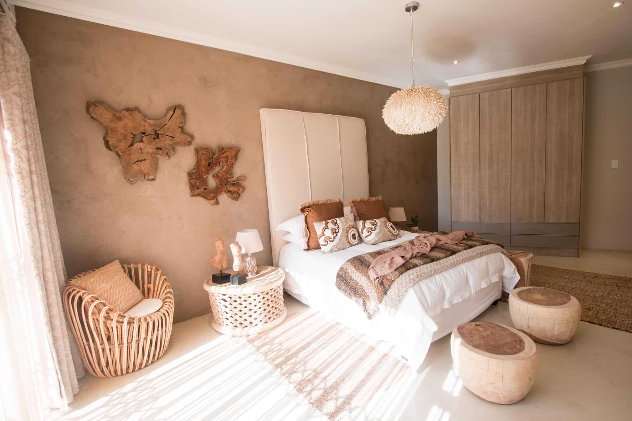 Luxury bedroom with natural tones, rattan chair, and textured wooden decor
