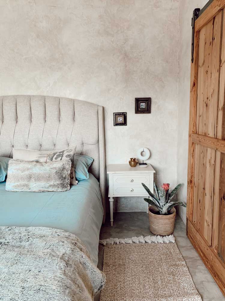 Cozy bedroom with light beige walls, blue bedding, and wooden sliding door