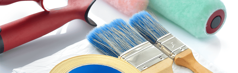 Assorted painting tools including brushes, rollers, and masking tape